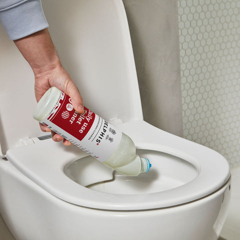Pouring daily toilet cleaner in the toilet