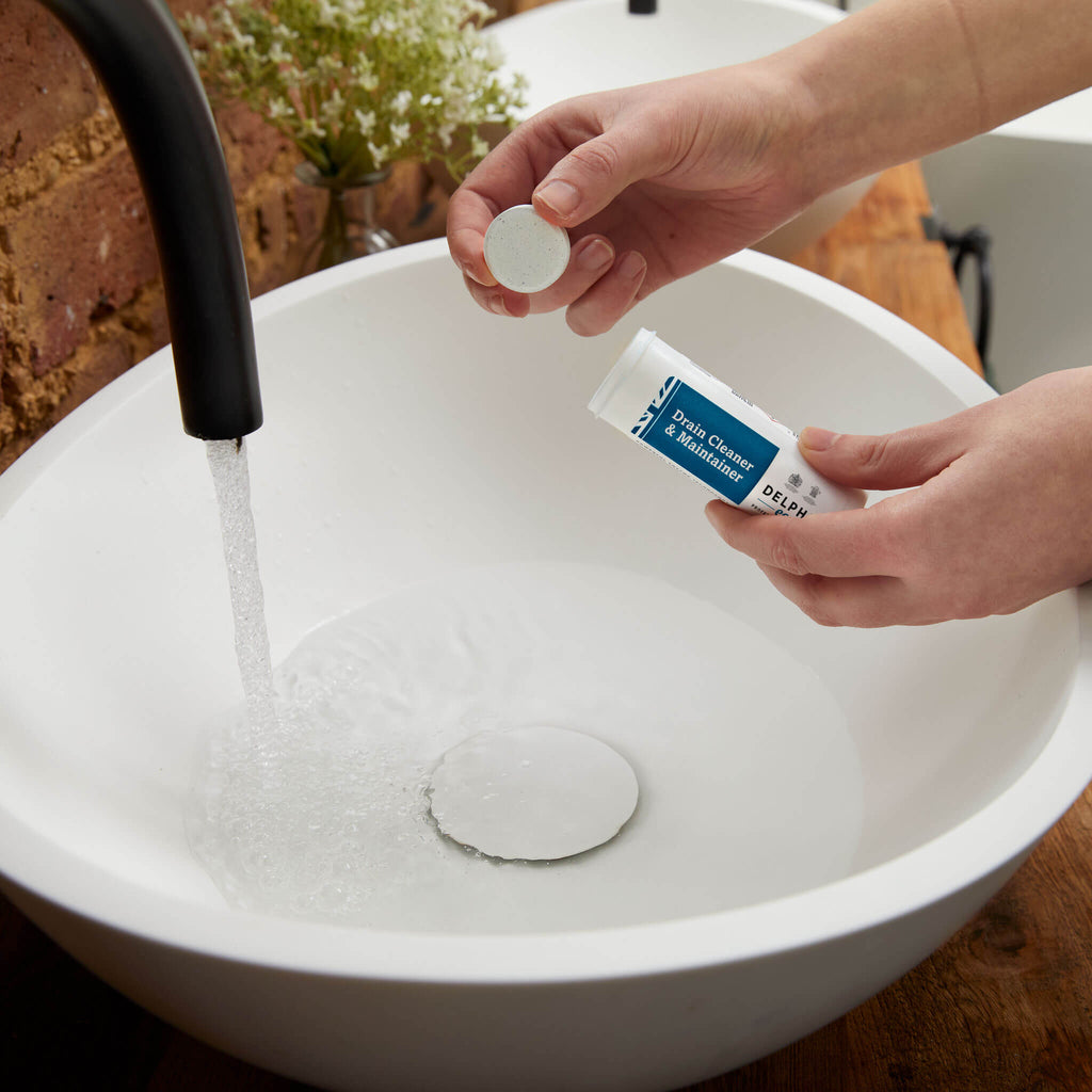 Delphis Eco Drain Cleaner and Maintainer eco-friendly drain cleaner in a porcelain sink with water running 